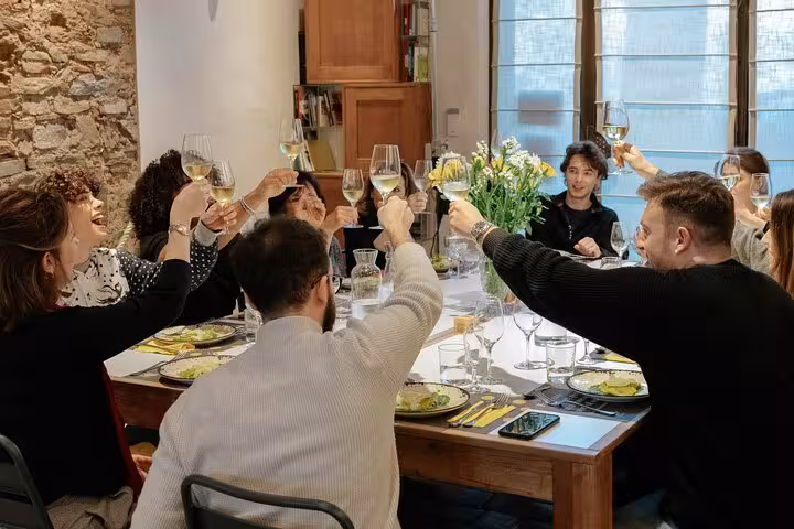 Guests enjoying a toast at MaMa Florence cooking class, celebrating with wine and gourmet pasta dishes.