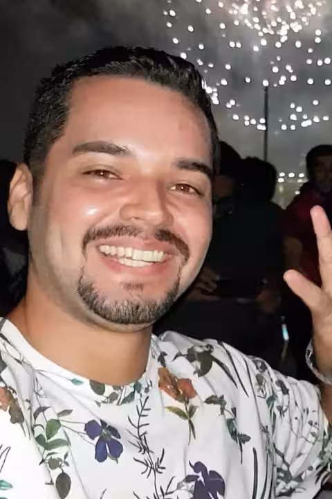 Smiling guest on Manaus Reveillon by boat party with fireworks sparkling in the background on Rio Negro