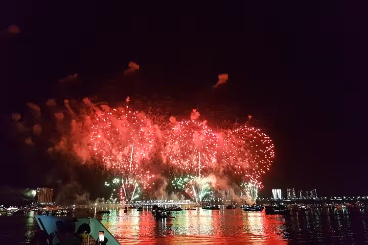 Red and green fireworks over Rio Negro on Manaus Reveillon boat party cruise with skyline reflections