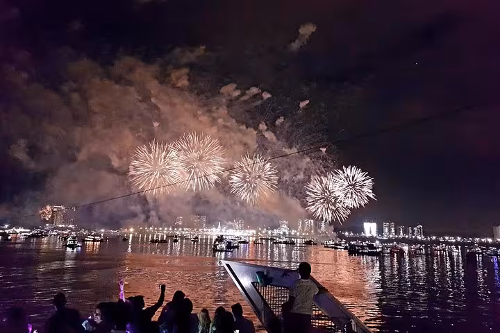 White fireworks above Manaus waterfront seen from a Reveillon boat tour on the Rio Negro at midnight