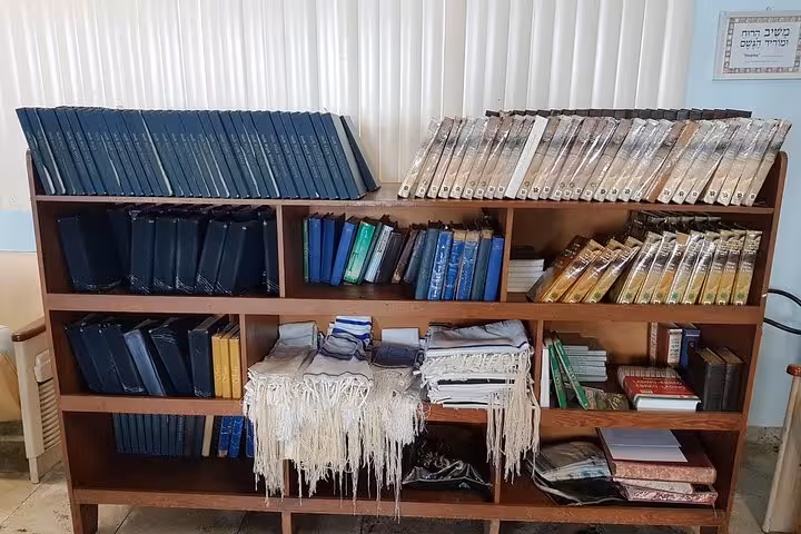 Prayer books and tallit on shelves inside Manaus synagogue, highlighting Jewish heritage tour in the Amazon