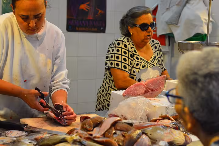 Local fishmonger skillfully preparing seafood at a traditional market in Marbella, featured in the small group food tour.