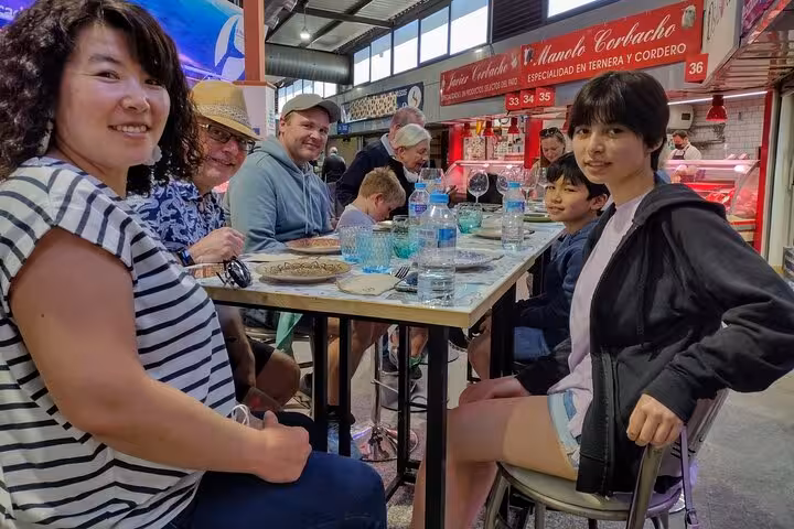 Group enjoying local delicacies at Marbella market during Taste of Marbella Food & Market Small Group Tour.