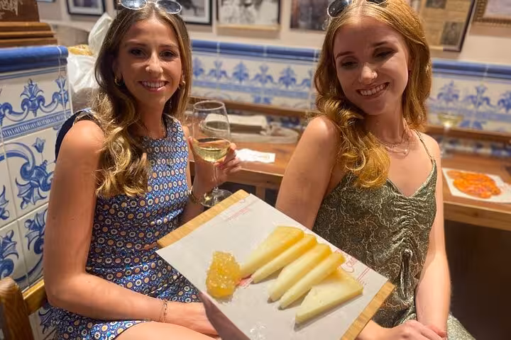 Two women enjoying wine and cheese at a traditional tapas bar during the Taste of Marbella Food Tour.
