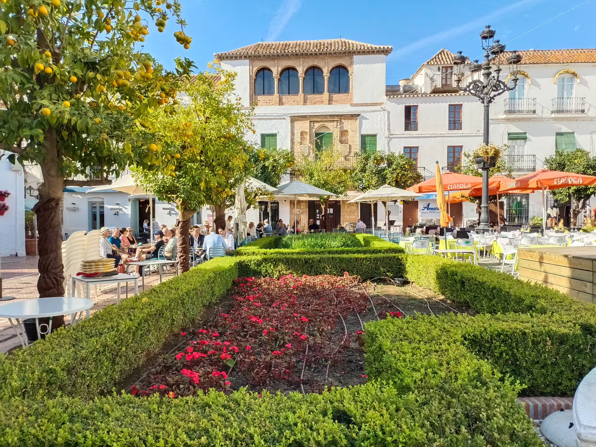 Marbella Old Town plaza on a guided group walking tour, with orange trees, cafés and historic facades