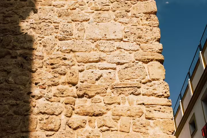 Sunlit ancient stone wall in Marbella Old Town highlights historic architecture on the private walking tour.