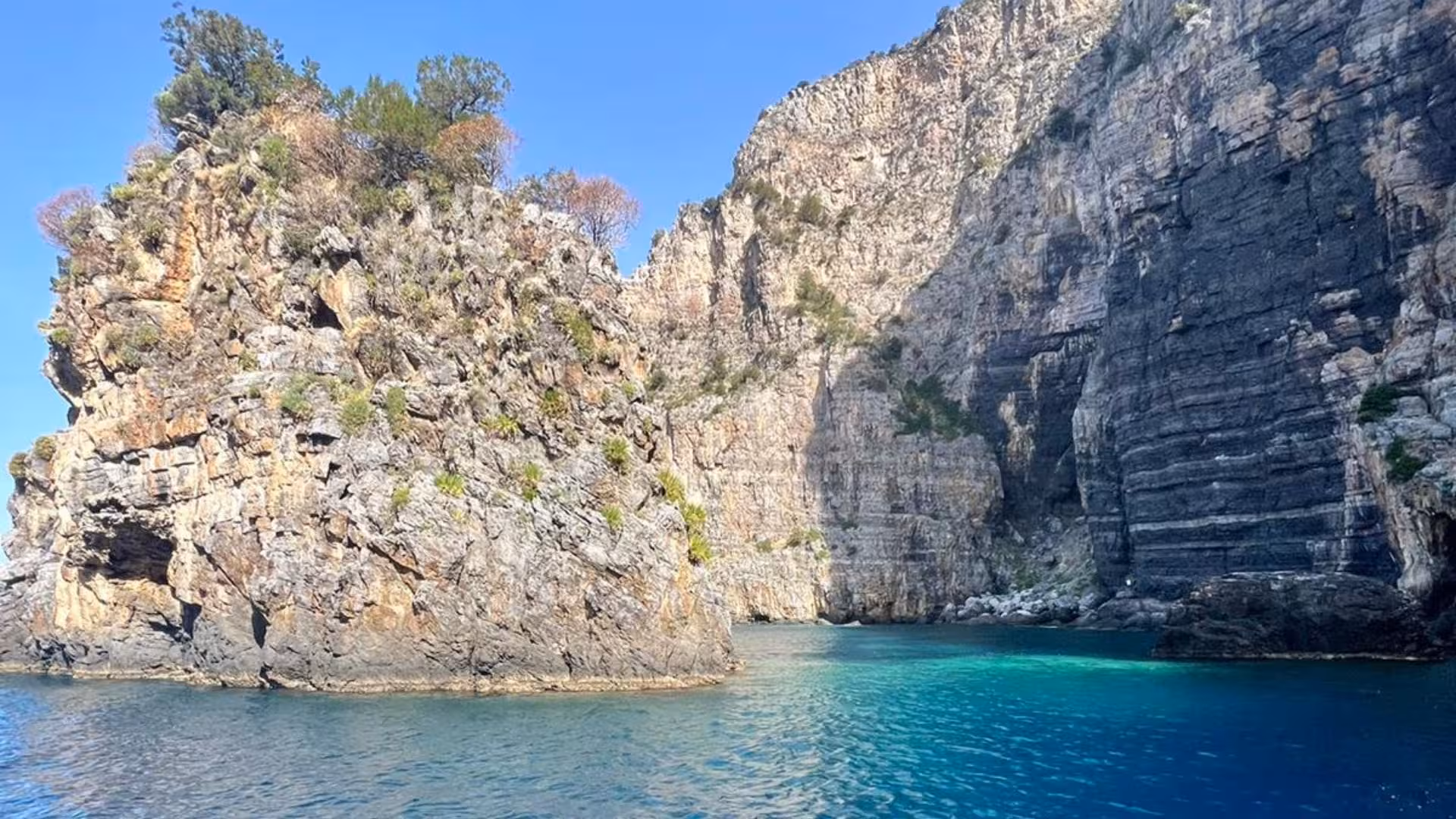 Scenic view of towering cliffs and azure waters in Baia Infreschi, perfect for a Marina di Camerota boat tour.