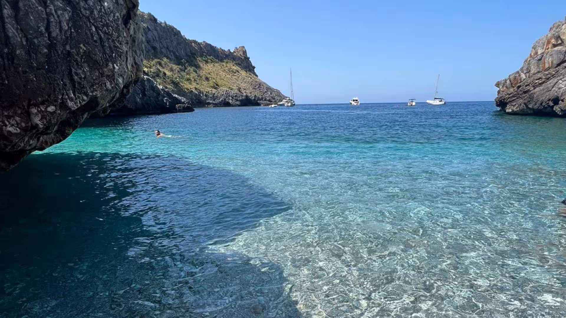 Idyllic clear waters with boats anchored near rocky cliffs, Baia Infreschi, Marina di Camerota boat tour.