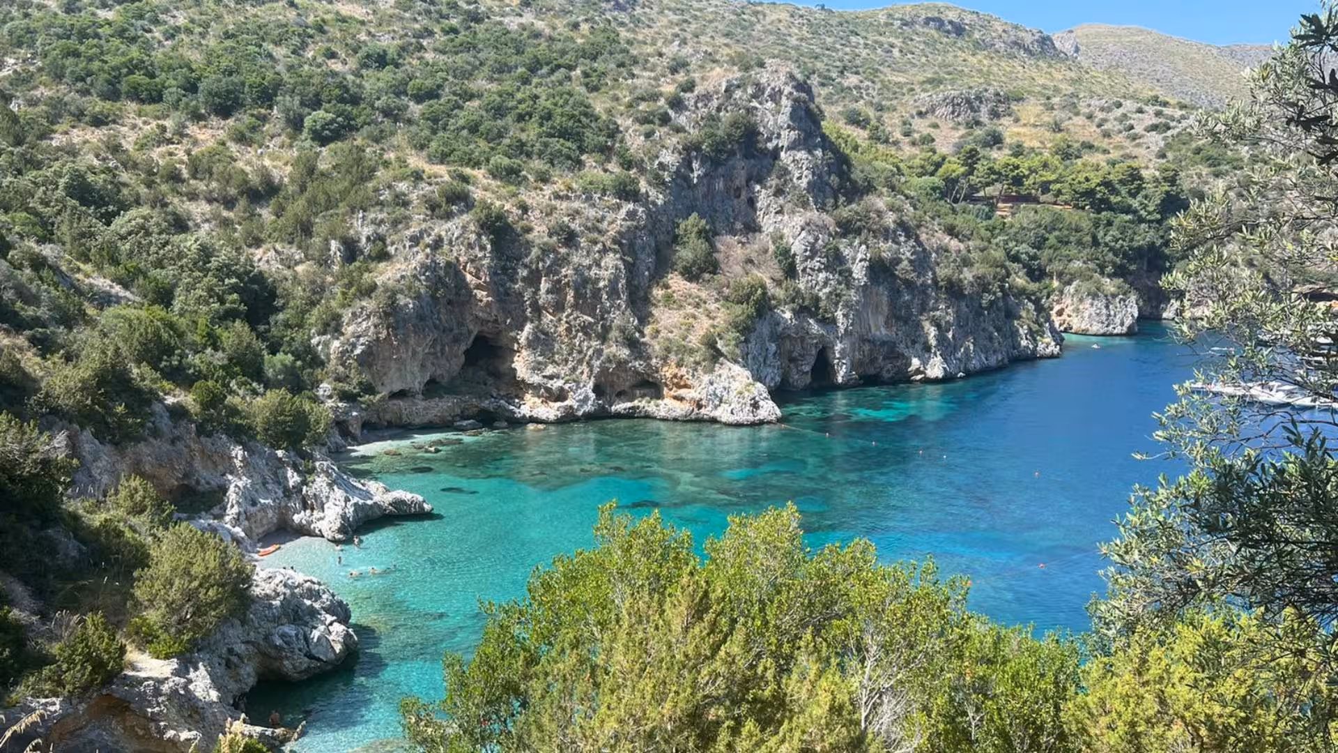 Breathtaking view of Baia Infreschi's crystal-clear waters and lush cliffs in Marina di Camerota.