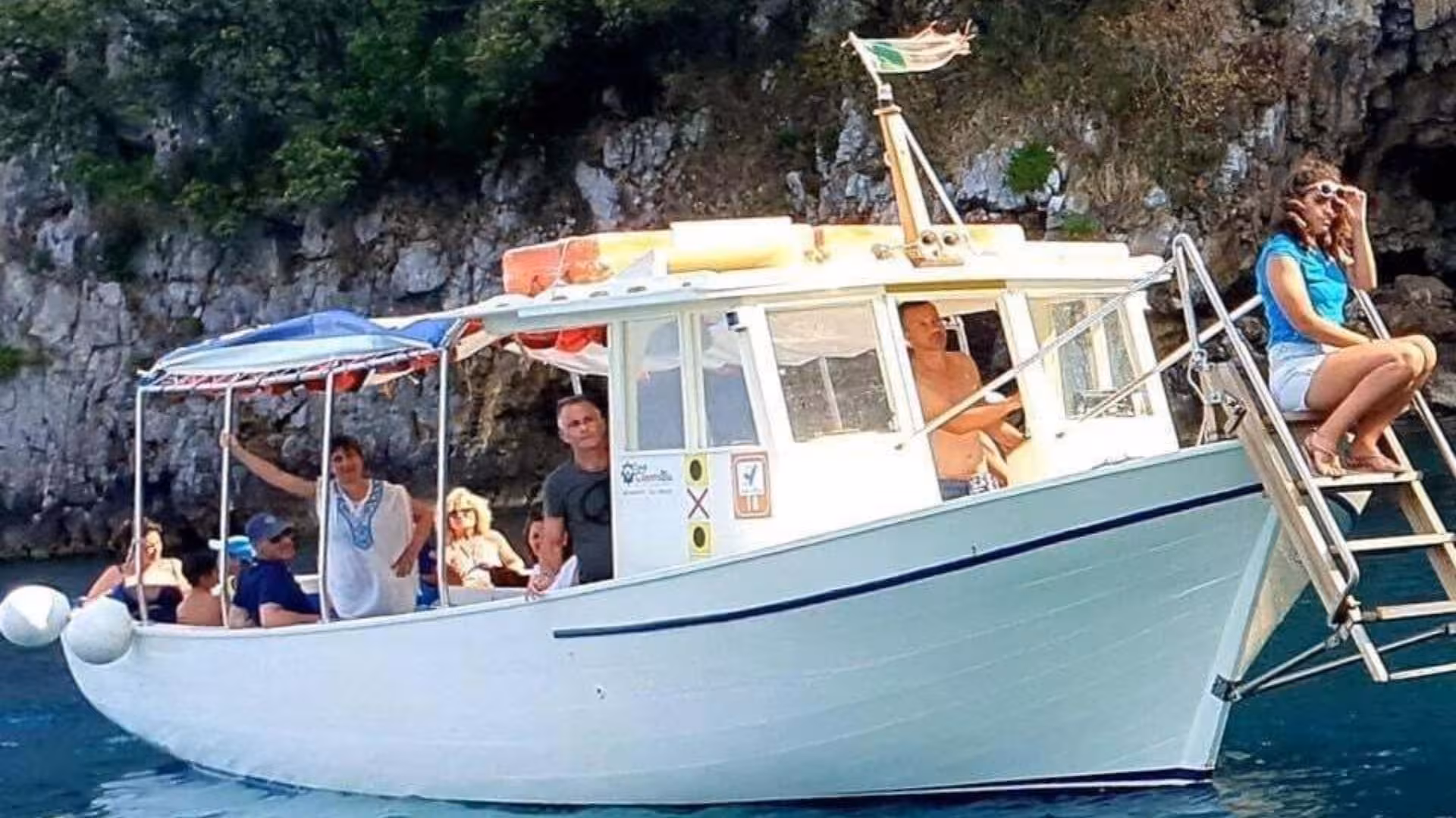 Tourists enjoy a scenic boat ride along the stunning coastline of Marina di Camerota's Baia Infreschi.