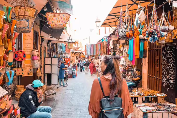 Traveler browsing colorful Marrakech souk stalls and crafts on Morocco 10-day tour from Casablanca