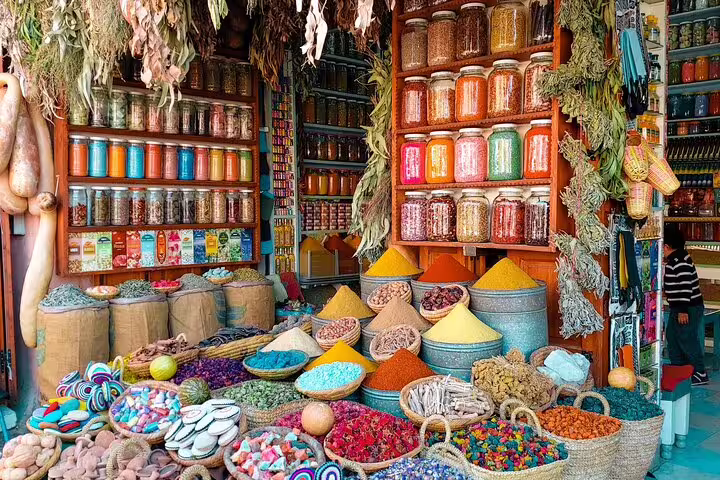 Colorful Marrakech spice market stall with jars, herbs and sweets, a highlight on Morocco 9 days tour
