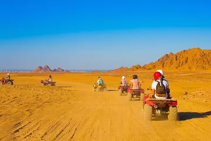 Marsa Alam ATV quad biking safari across desert plains and mountains, group ride with helmets and dust trail