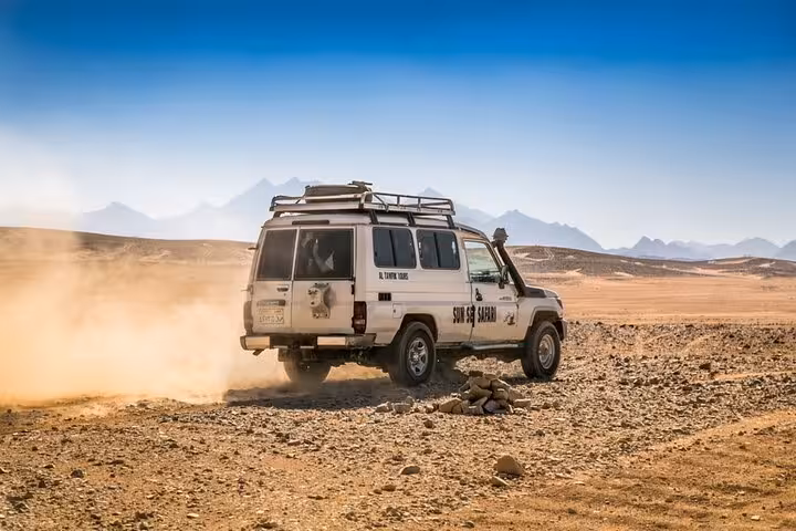 4x4 jeep speeding across Marsa Alam desert on adventure tour with quad biking, camel ride and dinner