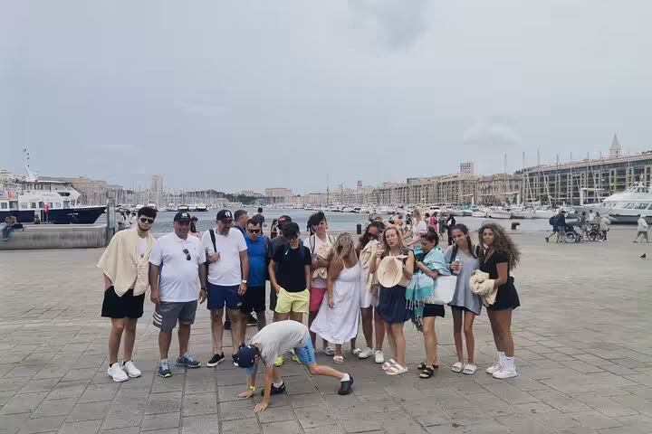 Group of travelers at Marseille Old Port meeting point before Blue Coast coves boat tour and cruise departure