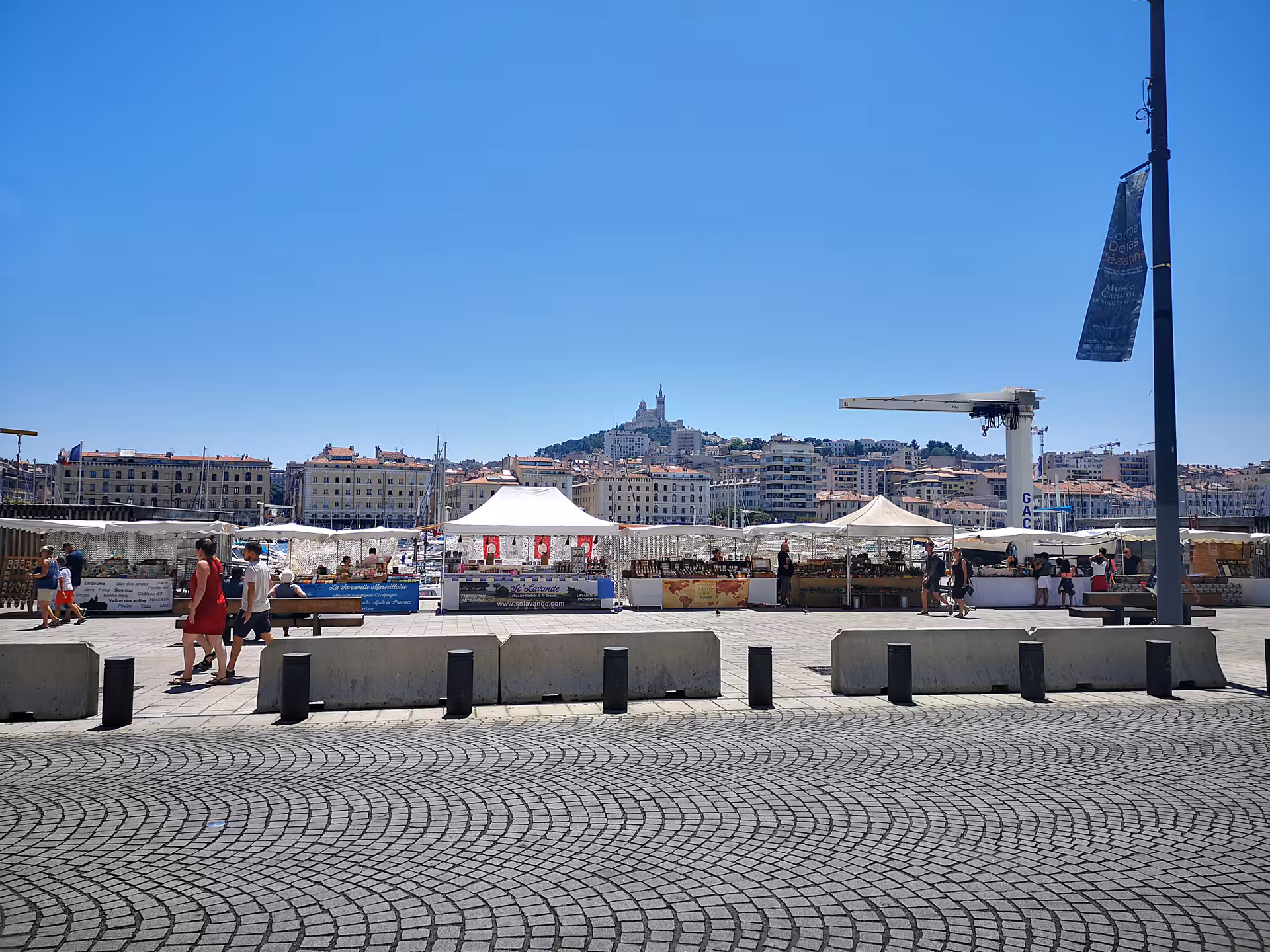 Marseille Vieux-Port market stalls with Notre-Dame de la Garde in the distance on a private day tour