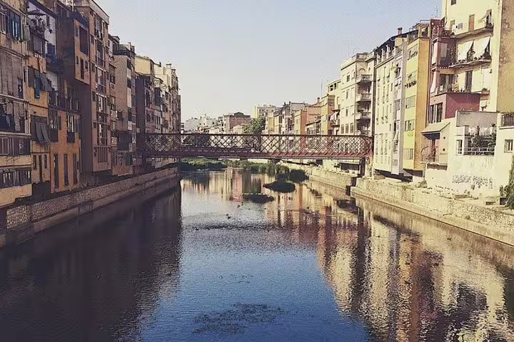 Picturesque river with historic buildings and bridge in a medieval town on a private guided tour.