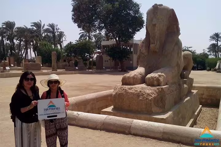 Travelers at Memphis open-air museum beside ancient sphinx statue, stop on Giza, Dahshur and Saqqara tour