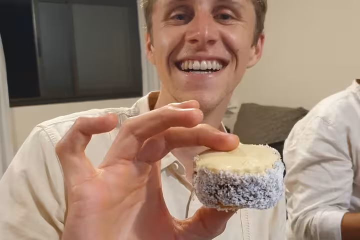 Smiling person holding an Argentine alfajor during a culinary tour featuring wine, vermouth, and fernet tastings.