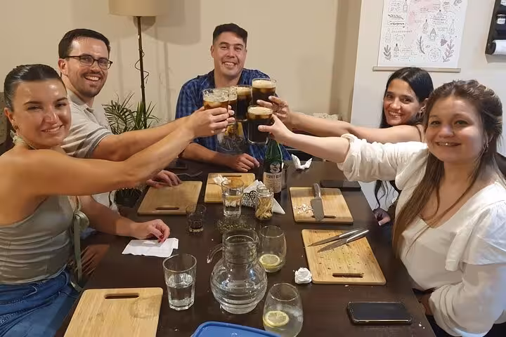 Group of friends toasting with glasses of Fernet at a cozy dining table, celebrating Argentinian flavors and camaraderie.