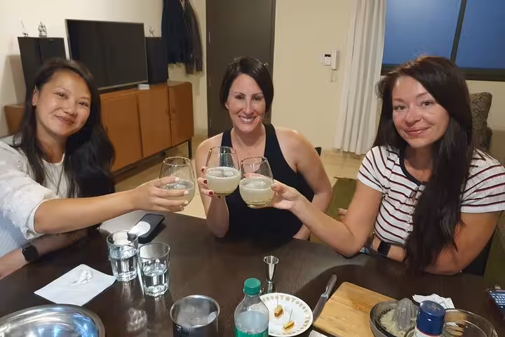 Three friends raising glasses of wine and vermouth, enjoying an authentic Argentinian culinary and beverage tour.