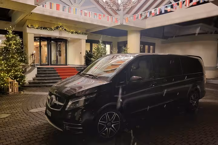 Premium Mercedes van at hotel entrance in winter, ideal for private transfer from Lucerne to Zurich airport or city