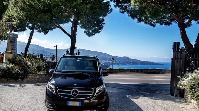 Black Mercedes van parked by the coast, ready for scenic private transfer between Naples and Benevento, Campania region
