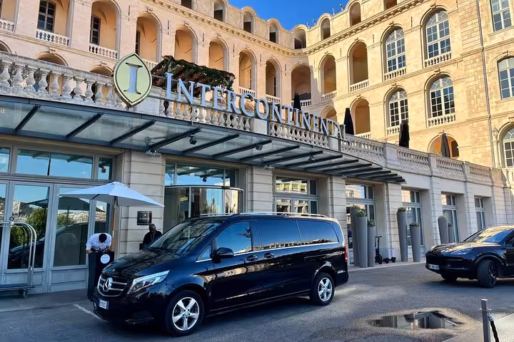 Spacious black Mercedes van ready for transfer service at a grand hotel, connecting Ravenna Cruise Terminal to Bologna Airport.