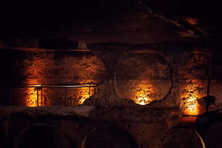 Warm-lit underground cave chamber with ancient stone walls, explored on a private guided Mesopotamia tour