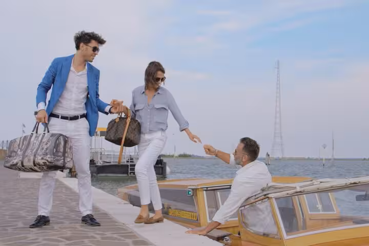 Elegant travelers boarding a water taxi in Mestre for a seamless transfer to Venice Airport, enjoying scenic views.