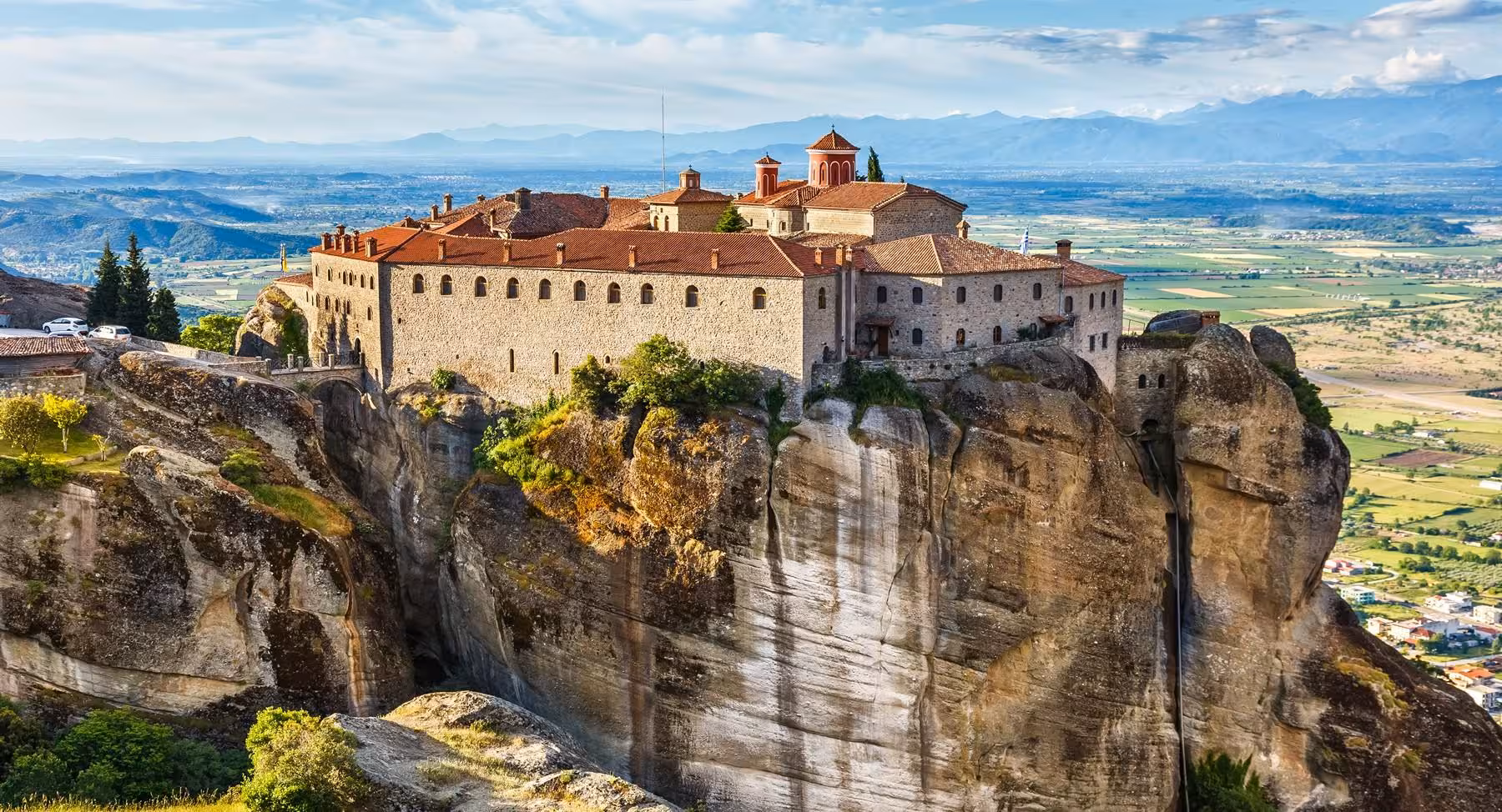Meteora cliff-top monastery with red roofs overlooking Thessaly plain on 2-day Delphi & Meteora tour