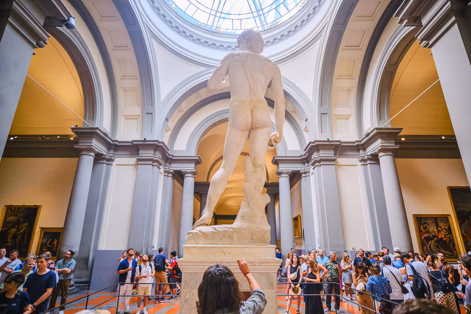 Crowds gather around Michelangelo's David at Accademia Gallery, enjoying a skip-the-line guided tour in Florence.