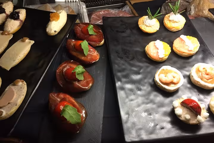 Assortment of gourmet appetizers beautifully arranged on black platters in a Michelin restaurant in Rome.