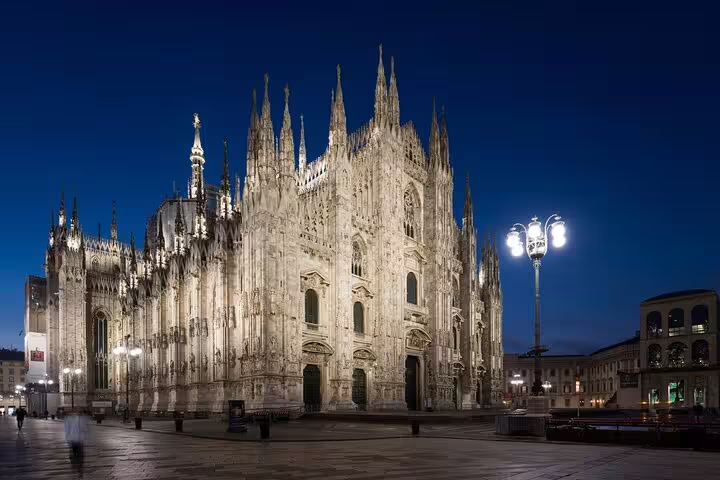 Experience the enchanting night view of Milan Cathedral illuminated against the evening sky during our exclusive tour.