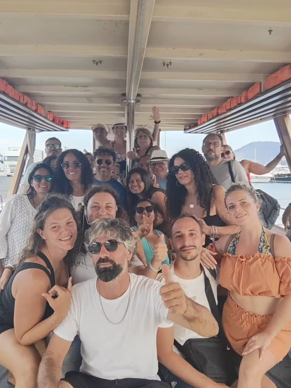 Group of travelers smiling on boat during Minicrociera Flegrea, scenic cruise in the Campi Flegrei bay
