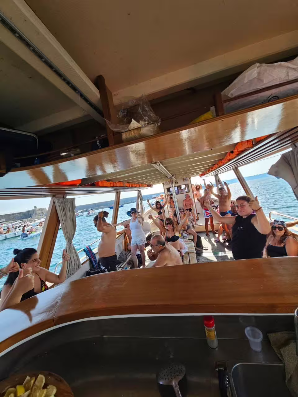 Gruppo in festa sul battello durante Minicrociera Flegrea, tour in barca nel Golfo di Napoli al tramonto