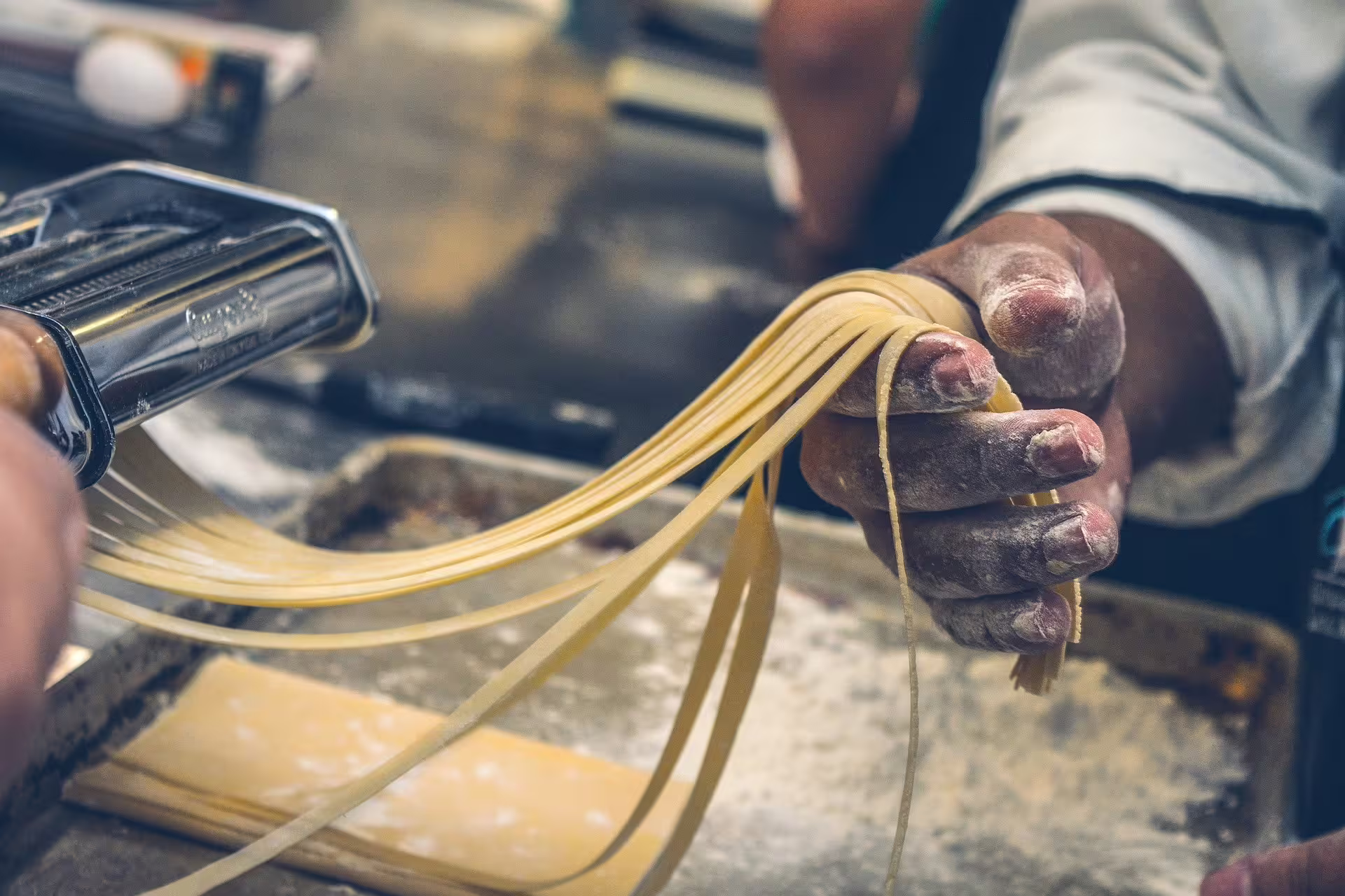 Fresh tagliatelle being cut by hand in Modena, perfect pairing for traditional balsamic vinegar tasting