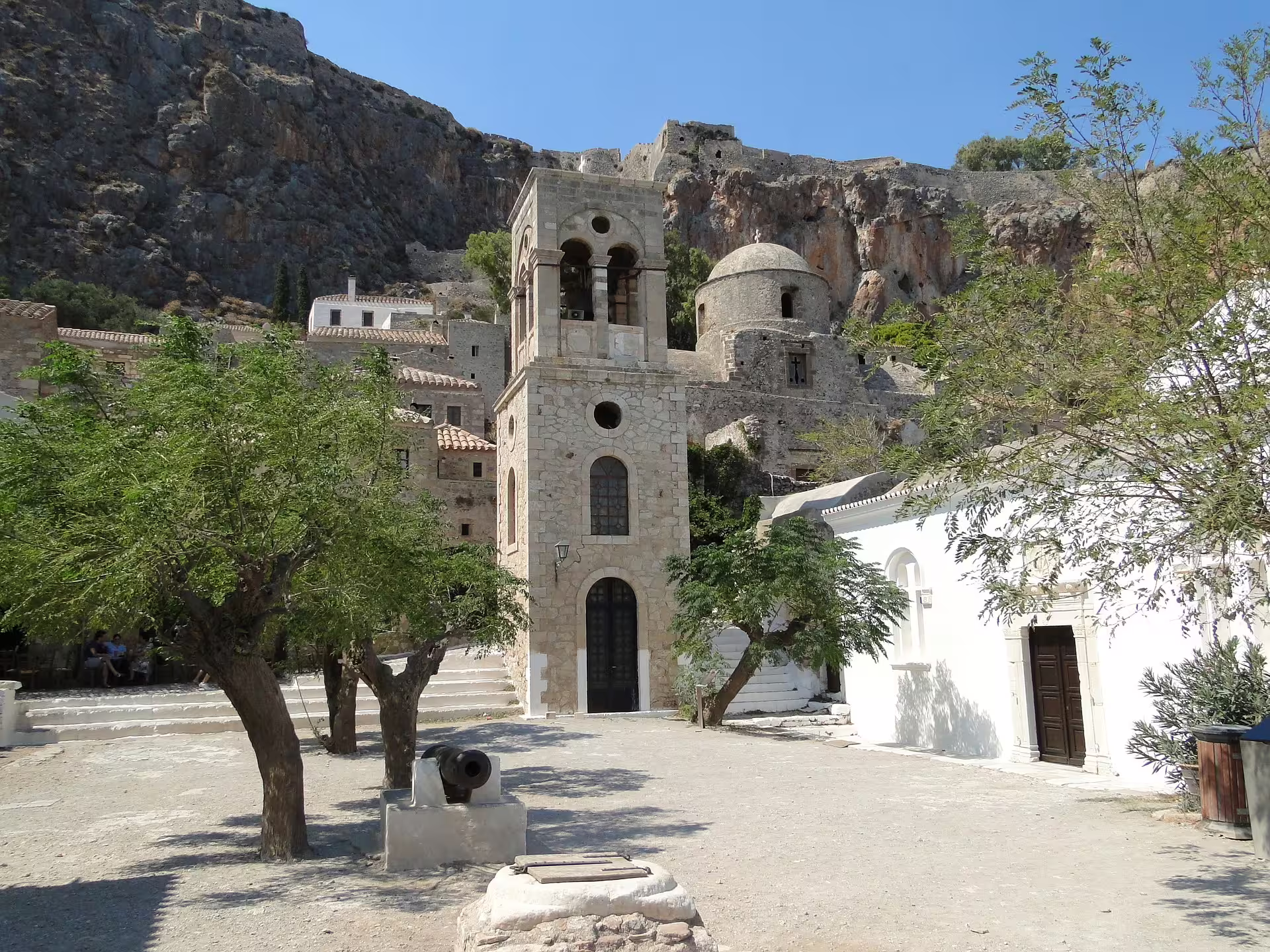 Monemvasia fortress village bell tower and white church beneath rocky cliffs on a 2-day private overnight tour