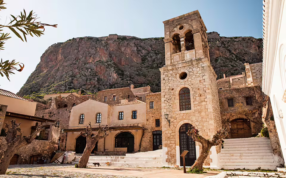 Monemvasia old town square with stone bell tower and cliff backdrop on a 2-day private tour from Sparta