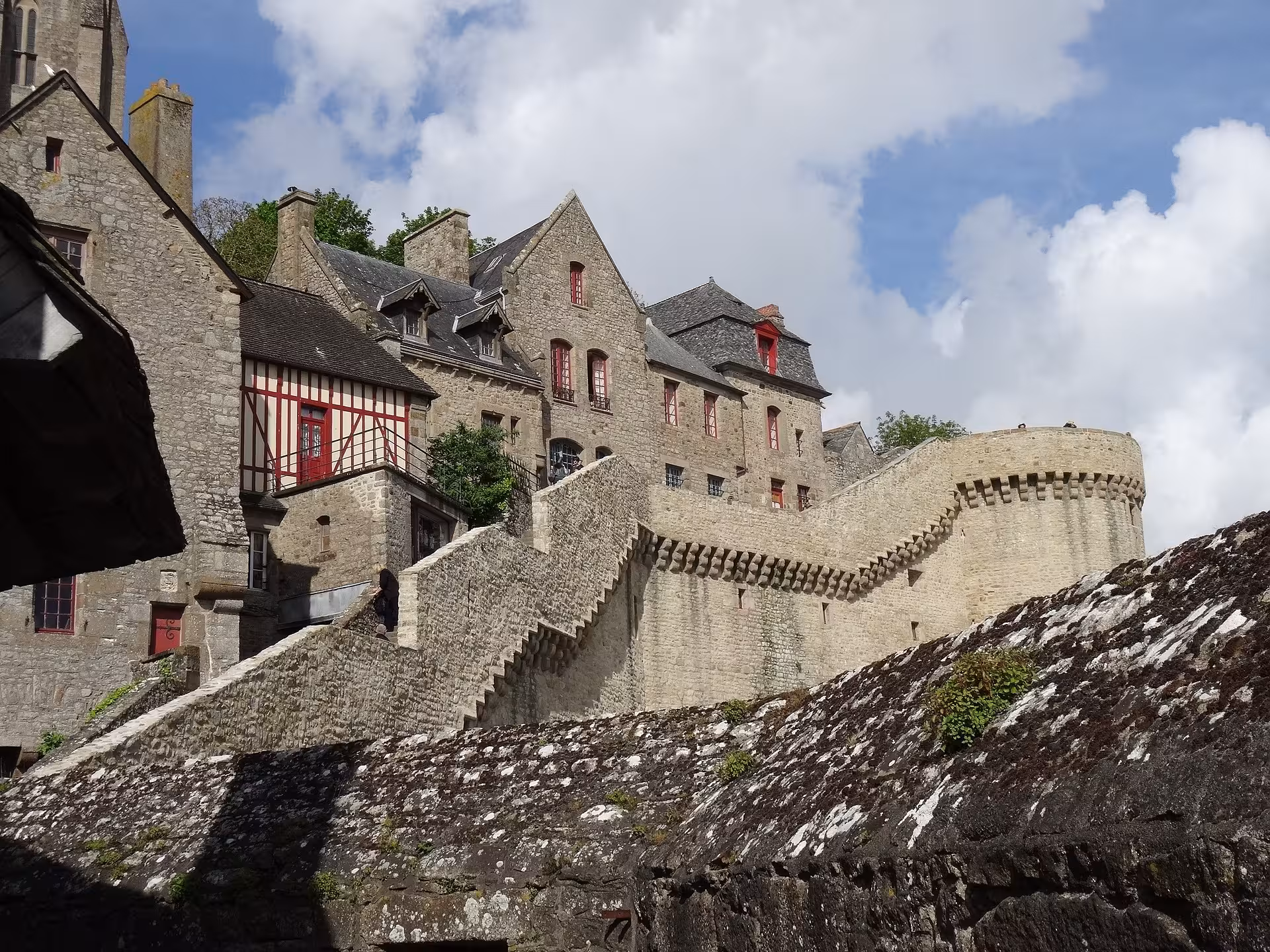 Stone houses and ramparts inside Mont Saint-Michel village, guided Normandy day trip in luxury minivan
