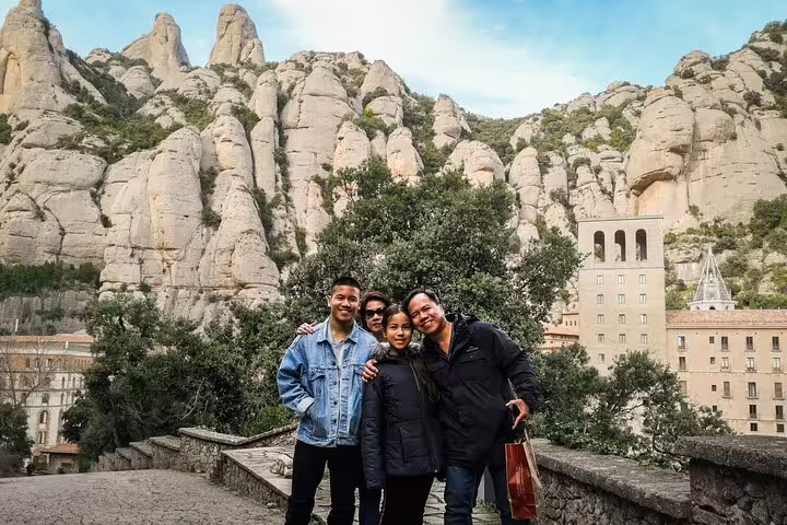 Tourists enjoying Montserrat mountain views during a private tour with La Moreneta access and hotel pickup service.