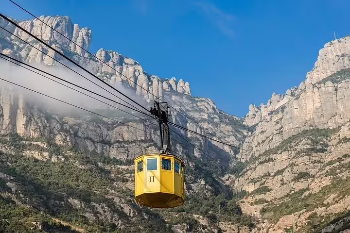Experience breathtaking views of Montserrat's rugged peaks from a scenic cable car ride, part of the Igualada balloon tour.
