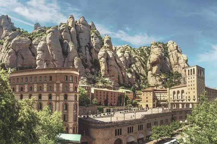 Scenic view of Montserrat Monastery nestled in rugged mountains, featured in private tour with La Moreneta access and hotel pickup.