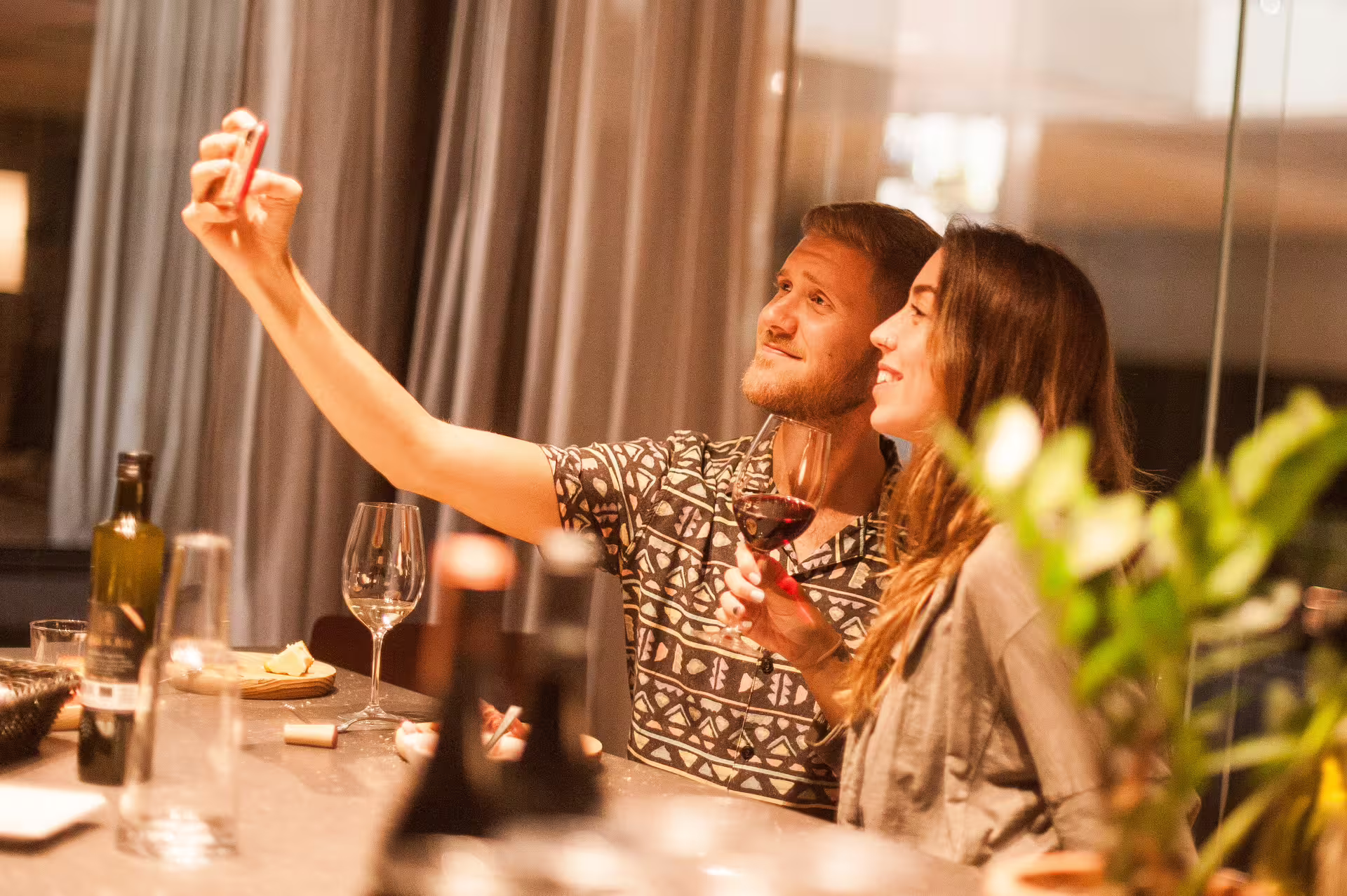 Couple enjoying Montserrat tapas and wine tour, capturing memories with a selfie at a cozy bar setting.