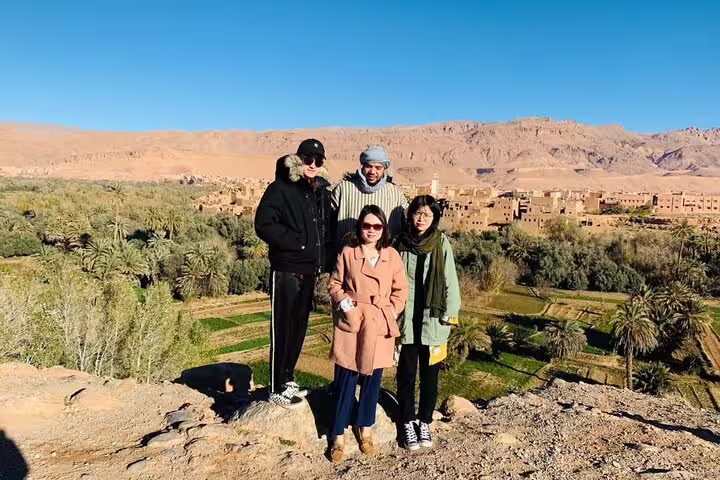 Travelers at Dades Valley viewpoint on Morocco 9 days tour from Marrakech, Berber village and palm oasis views