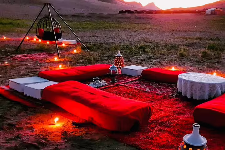 Sunset desert camp dinner setup with lanterns and Moroccan tea, highlight of 11 day Marrakech tour