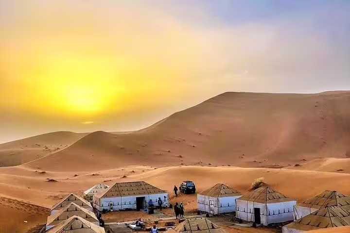 Luxury desert camp at sunset in Merzouga Sahara dunes, overnight stop on Morocco 9 day tour Tangier to Marrakech