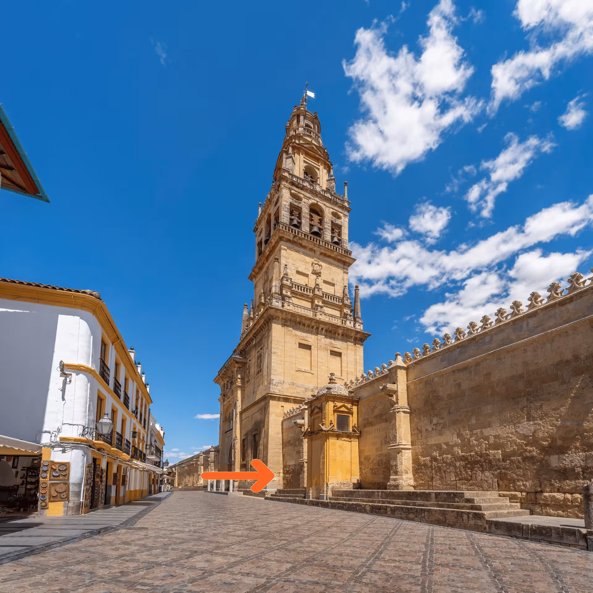 Majestic tower of Mosque-Cathedral of Córdoba under a vibrant blue sky, ideal for cultural tour exploration.
