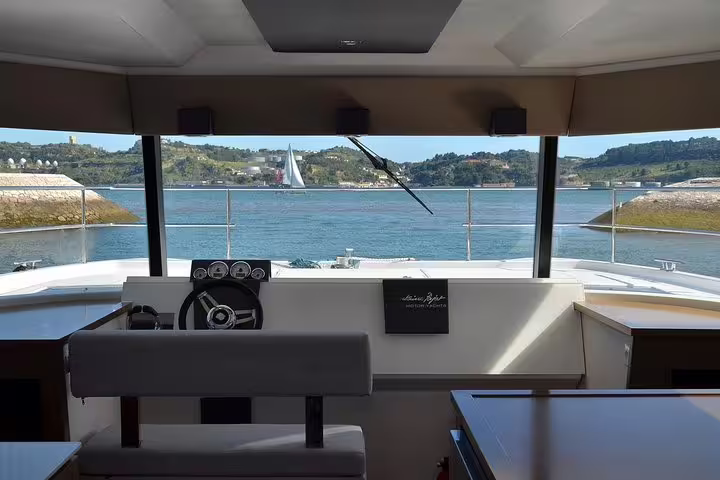 Interior view of a motor catamaran in Lisbon, showcasing panoramic windows and serene river views, perfect for a relaxing cruise.