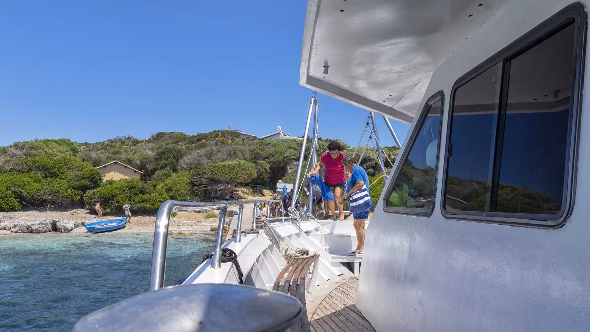 Passengers boarding motorboat for a scenic tour of La Maddalena Archipelago from Santa Teresa di Gallura.